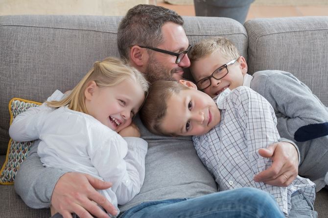 Father hugging 3 kids